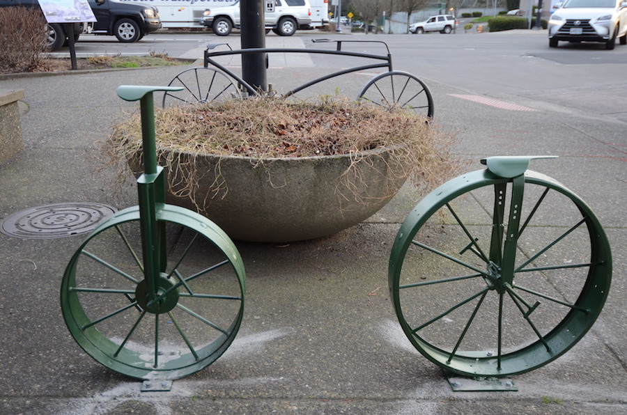 Two bike racks in front of Jazzy Bagel.