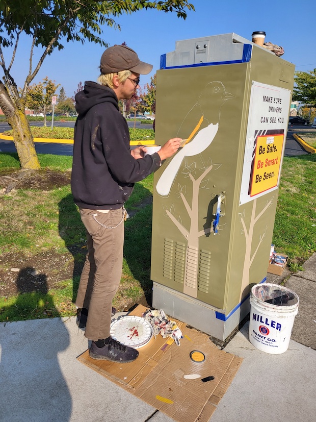 Madison outlining the Spotted Towhee on an electrical box.