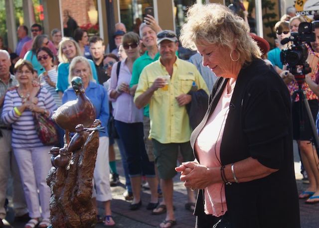 Lynn looking at Bless Our Nest statue