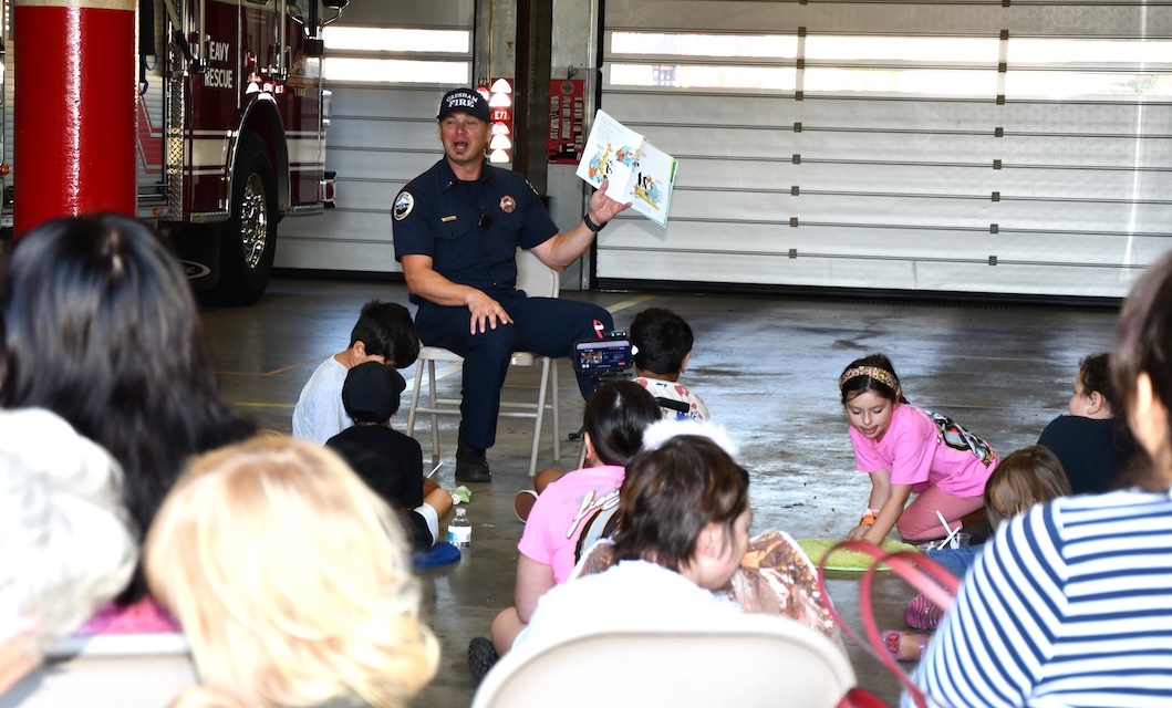Firefighter reading storybook to room of children