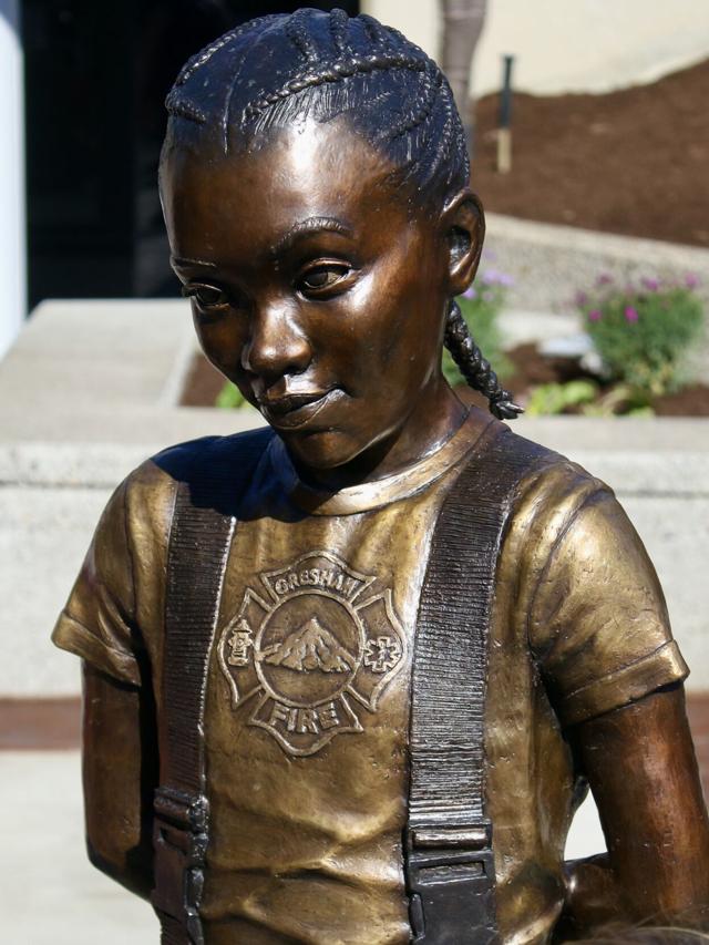 Young girl in firefigther gear.