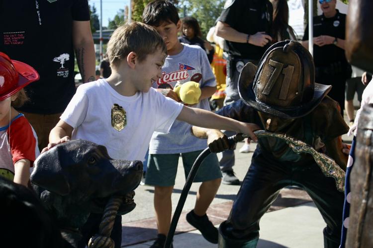 Boy plays with water boy statue is drinking.