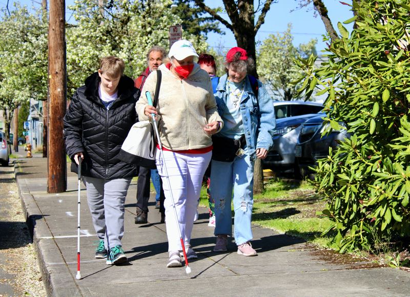 Group of people walking down the side walk.